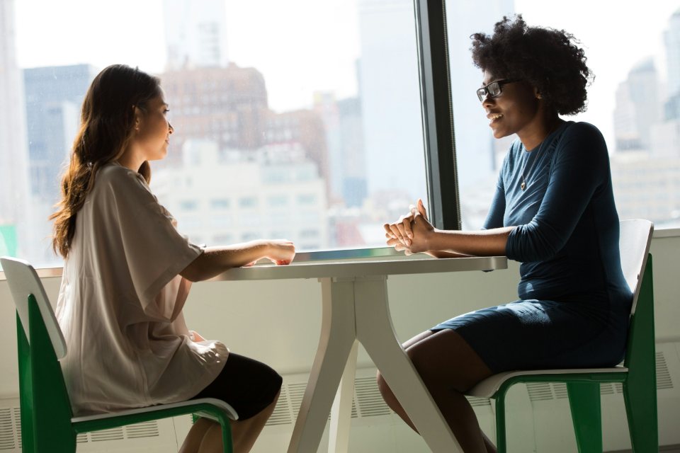 Dos mujeres sentadas hablando